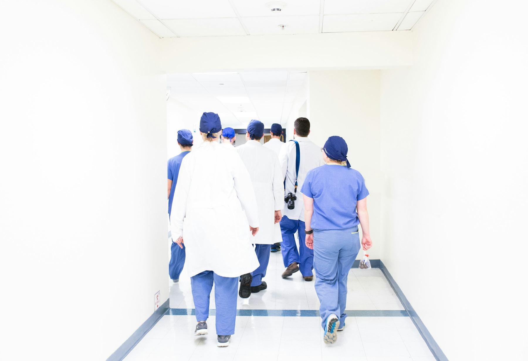 Une équipe soignante s'éloigne dans le corridor d'un établissement.